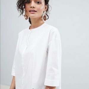 White structured top with gold button accent